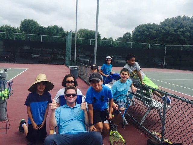 Junior tennis students practicing together on court