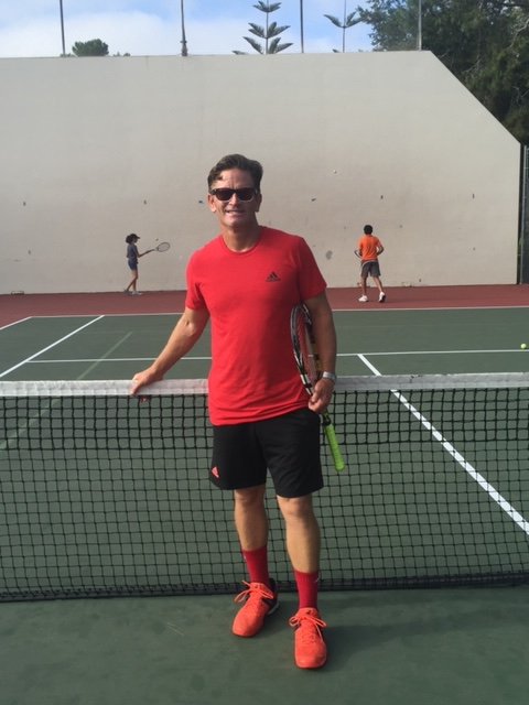 Coach Jimmy Gleason standing on a tennis court